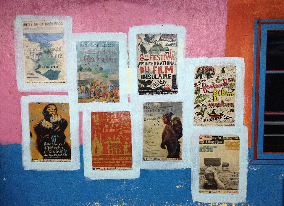 Affiches de festival collées sur un mur coloré